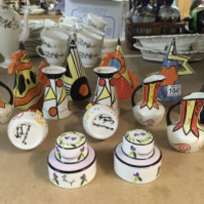 A collection of Lorna Bailey pottery, including small jugs with "Twentyone" to the bases, miniature vases with, miniature cakes and Fire, sunset and Thunderbolt sugar shakers