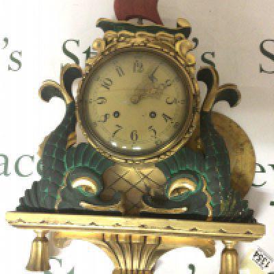 A Swedish wall clock gilt wood Gesso and painted. In the form stylised dolphins the case top surmounted with a sailing ship. With pendulum Hight 60cm- NO RESERVE