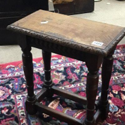 An Early 19th century English Vernacular carved oak coffin stool the top with carved edge on turned legs united by stretchers. Hight 51cm- NO RESERVE