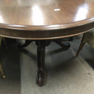 A Victorian mahogany circular dining table on scrolled legs .