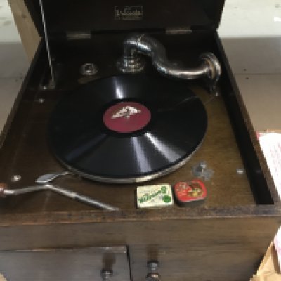 A oak table top gramophone with records .