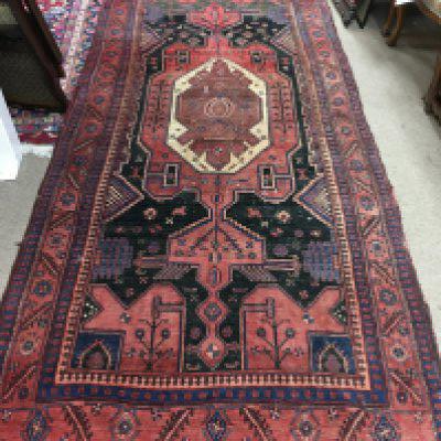 A Persian wool rug. Approx measurements 313x126cm.