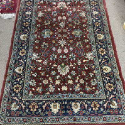 A Persian wool rug with floral patterns. Approx measurements 162x101cm.