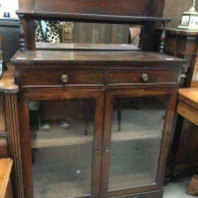 A Victorian mahogany chiffonier, the raised back above two drawers and a pair of glazed doors in a plinth base. 90cm x 40cm
