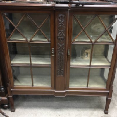 An Edwardian mahogany display cabinet with a pair of glazed doors inclosing shelves on square tapering legs. 130cm x 122cm x 40cm