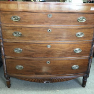 A Victorian mahogany bow fronted chest of drawers fitted with four drawers on turned legs