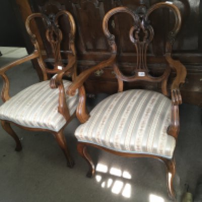 A pair of Edwardian mahogany open arm chairs on cabriole legs