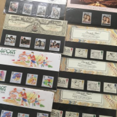 A box containing a large quantity of Royal Mail presentation packs.