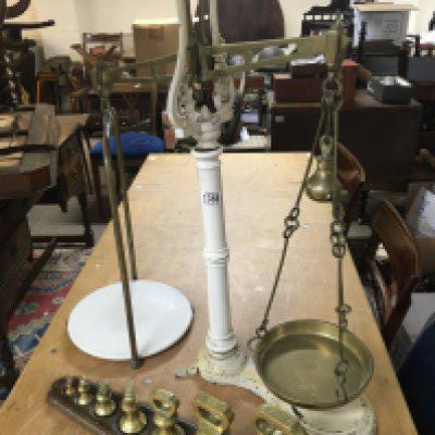 A set of antique enamel beam balance scales with brass fittings and a set of graduating brass bell weights.- NO RESERVE