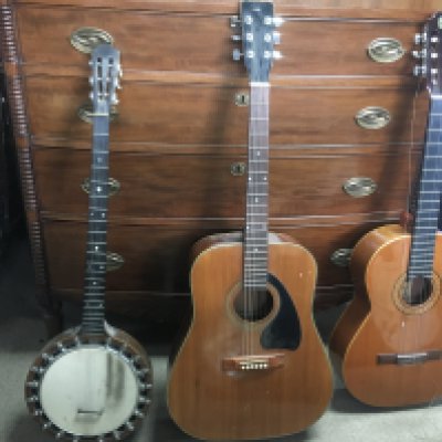 A Tapa Maciza Admira solid top classical style acoustic guitar, an unmarked acoustic guitar and a six string banjo. With one soft and one hard case