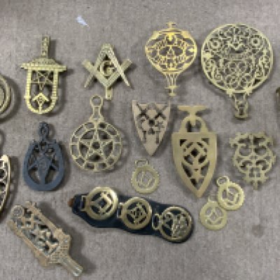 A collection of Masonic related brass trivets and horse brasses.