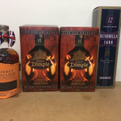 Four bottles of whiskey including Dimple , bushmills and monkey Shoulder .