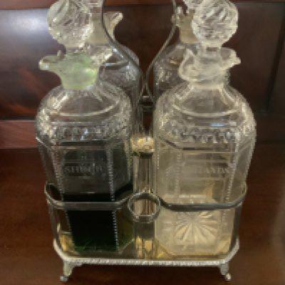 A Victorian silver plated mahiogany cased 4 bottle tantalus, Cut and engraved bottles glass bottles.