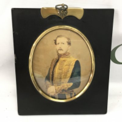 A framed ebonised photograph portrait of a gentleman in military dress.