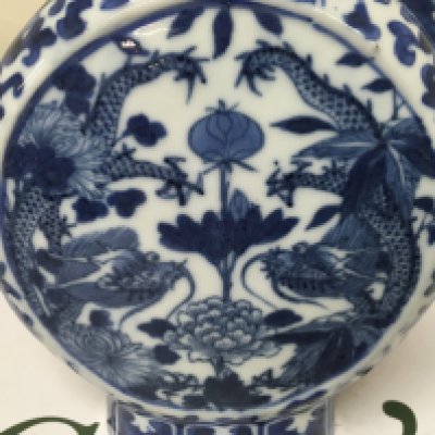 A Chinese blue and white moon flask decorated with dragons flowers and foliage and one other Chinese vase .