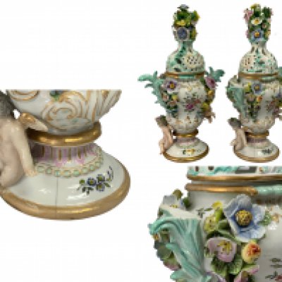 A pair of 19th Century German porcelain pot pourri vases and covers with cherub and floral decoration. 36cm. (Some areas of damage).
