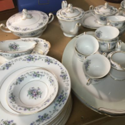 A Noritake Dinner/ tea set decorated with flowers and foliage included plates tureans teapots and plates .
