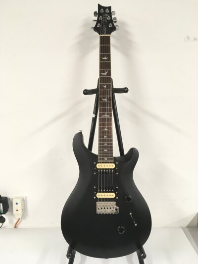 A PRS Standard SE electric guitar in a matt black finish. Comes with a soft carry case.