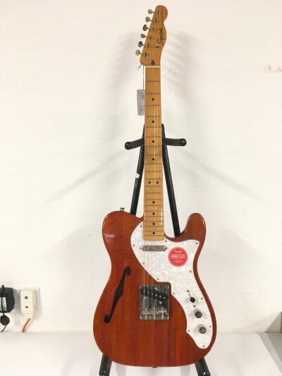 A Fender Squier thinline telecaster electric guitar. Comes with soft carry case.