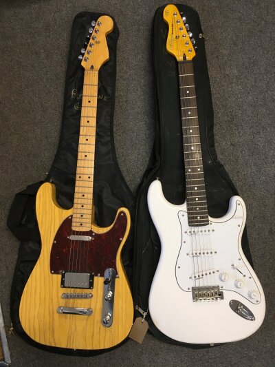 Two electric guitars comprising a Telecaster (Fender neck plate but no decals on neck) and a Vintage reissue V6 Staratocaster style guitar. Both come with soft carry cases.