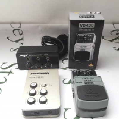 A Fishman Platinum Stage pre amp unit, a boxed VD400 vintage delay pedal and a Yoga mic connecting box.