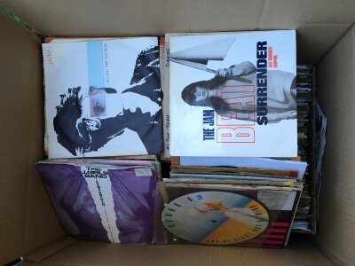 A box of 7" singles by various artists including The Jam, Elton John, Japan and many more.