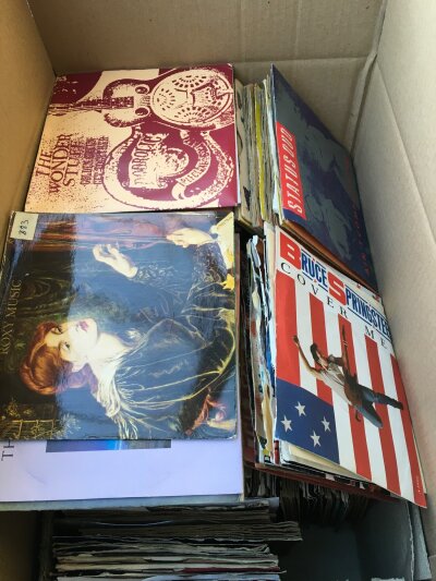A box of 7" singles by various artists including Sex Pistols, The Stranglers, Bruce Springsteen and many more.