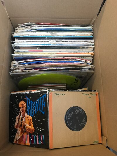 A box of LPs, 12" and 7" singles by various artists including The Beatles, David Bowie, Pink Floyd and many more.