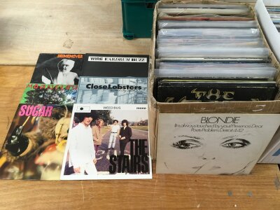 A box of 12" singles by various artists including Leather Nun, Wire, Sugar, The Cult and others.
