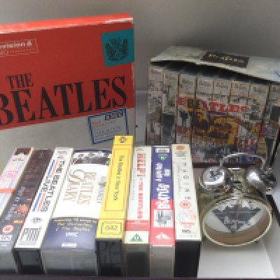 A Beatles 'Archives' book by Kevin Howlett, VHS tapes and a Beatles alarm clock.