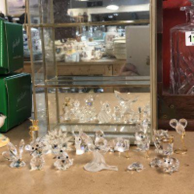 A collection of Swarovski figures and a display case. This lot cannot be posted
