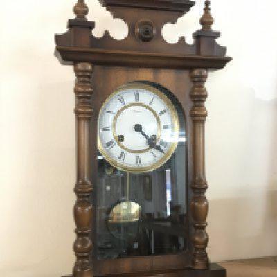 A German Rapport Wall clock with key and pendulum , 23cm tall approximately. This lot cannot be posted