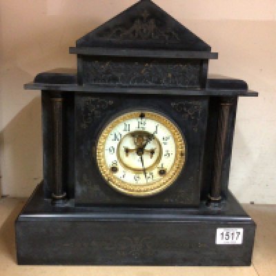 A black slate mantel clock having Roman numerals and visible escapement. NO RESERVE