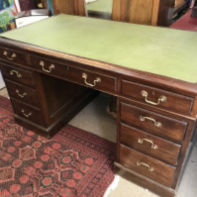 A three piece oak pedestal writing desk, 135cm wide 77cm tall.