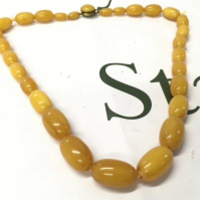 A bakelite amber necklace, 60cm long , 71g total weight. Postage category A
