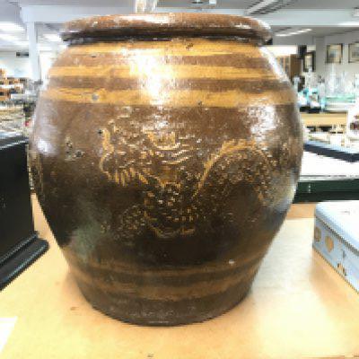 A large Chinese pottery plant pot decorated with dragons on a brown ground, 35cm tall. This lot cannot be posted