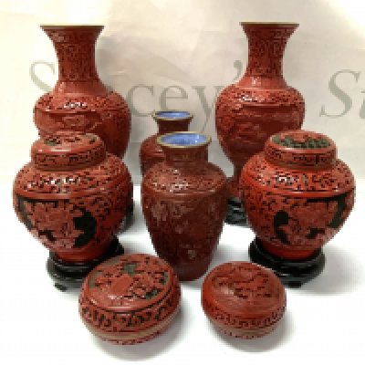 A collection of carved cinnabar vases.
