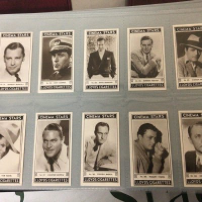 Five albums containing well presented cigarette cards postcards including coin cards with National flags Turf cigarettes cards playing cards vintage cigarette packets pop stars cards Lloyds cigarettes cards Tucks postcards and numerous others in five albums. (5)