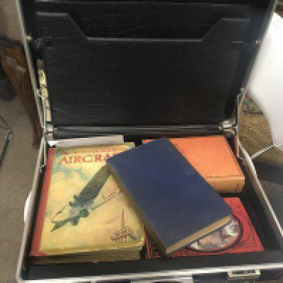 A collection of boxes of books mainly Civil Aviation books VHS videos and DVD and a briefcase containing books.